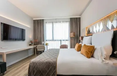 a hotel room with a large bed and a television at Leonardo Royal Hotel Barcelona Fira in Barcelona