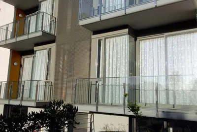 an apartment building with balconies and plants in front of it at Apartaments Can Negret in Sitges