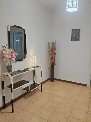 a living room with a tv and a table with flowers at Apartamento duplex vacacional in Arenys de Mar