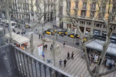 a group of people walking on a busy city street at Hostal MiMi Las Ramblas in Barcelona