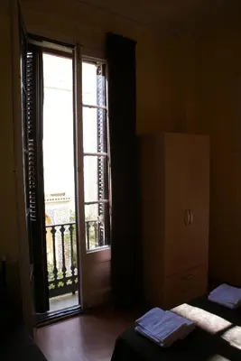 a room with a large window and a door at Hostal MiMi Las Ramblas in Barcelona