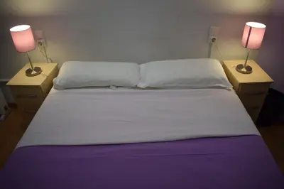 a bed with two lamps on two night stands at Hostal MiMi Las Ramblas in Barcelona