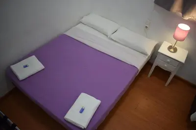 a small bed in a small room with a table at Hostal MiMi Las Ramblas in Barcelona