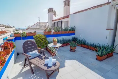 a patio with a table and chairs on a balcony at Angel Views Penthouse by Hello Homes Sitges in Sitges