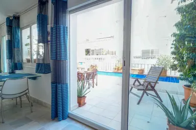 a room with a balcony with a table and chairs at Angel Views Penthouse by Hello Homes Sitges in Sitges