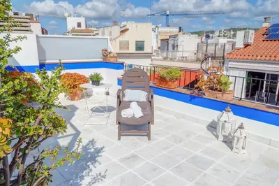 a patio with a chair and a table on a roof at Angel Views Penthouse by Hello Homes Sitges in Sitges