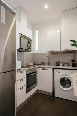 a kitchen with white cabinets and a washer at Cute Apartment in Barcelona