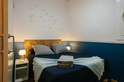 a bedroom with a blue bed with a blue wall at Cute Apartment in Barcelona