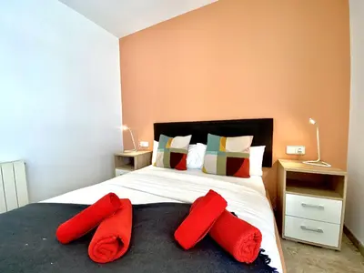a bedroom with a bed with red pillows on it at Duplex oasis in Sitges