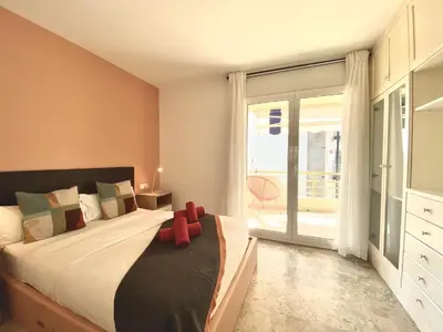 a bedroom with a bed and a large window at Duplex oasis in Sitges