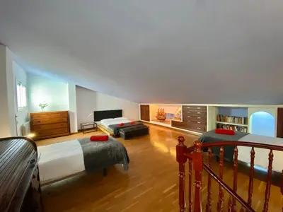 a large bedroom with two beds and a couch at Duplex oasis in Sitges