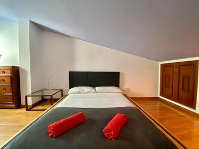 a bedroom with a large bed with red pillows on it at Duplex oasis in Sitges