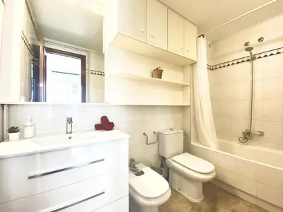 a white bathroom with a toilet and a sink at Duplex oasis in Sitges