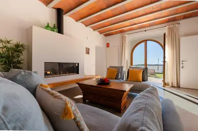 a living room with two couches and a fireplace at Villa Masia Capdet in Sant Pere de Ribes