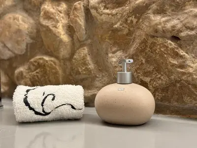 a white soap dispenser sitting next to a towel at Villa Masia Capdet in Sant Pere de Ribes