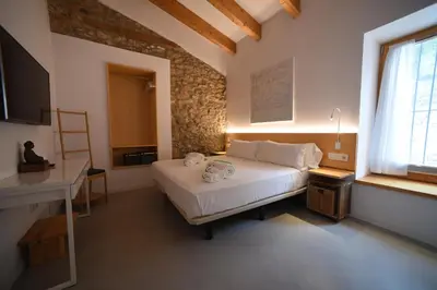 a bedroom with a bed and a desk and a window at Villa Masia Capdet in Sant Pere de Ribes