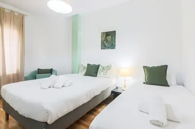 two beds in a room with white and green at Be barcelona arco del triunfo sunny colors III in Barcelona