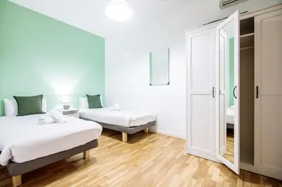 a bedroom with two beds and a mirror at Be barcelona arco del triunfo sunny colors III in Barcelona