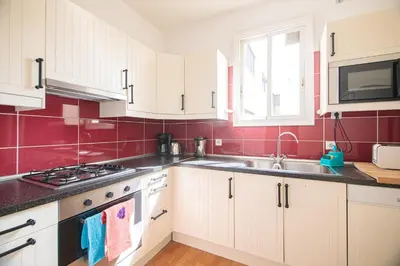 a kitchen with white cabinets and a sink at Be barcelona arco del triunfo sunny colors 2 in Barcelona