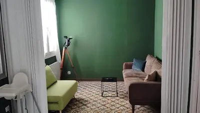 a living room with a couch and a green wall at Be barcelona arco del triunfo sunny colors 2 in Barcelona