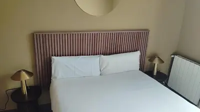 a bedroom with a bed with white sheets and two lamps at Be barcelona arco del triunfo sunny colors 2 in Barcelona