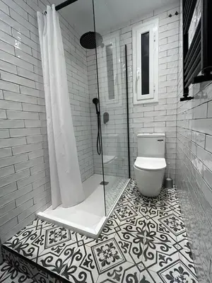 a bathroom with a shower and a toilet on a tiled floor at Be barcelona arco del triunfo sunny colors in Barcelona