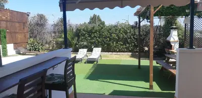 a patio with two lawn chairs and an umbrella at Edard's Private Villa in Castelldefels