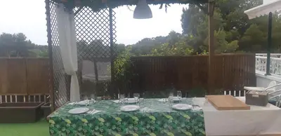 a table with plates on it in a backyard at Edard's Private Villa in Castelldefels