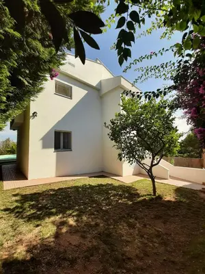 a white house with a tree in the yard at Edard's Private Villa in Castelldefels