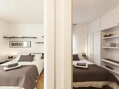 two beds in a bedroom with white walls at Lets holidays apartment in Sant Martí in Barcelona