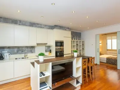 a kitchen with white cabinets and a counter top at Apartment Centro- Passeig de Gracia - Casa Batllo by Interhome in Barcelona