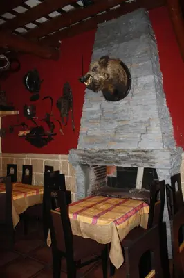 a bear sitting on top of a stone fireplace at Hostal Restaurante La Diligencia in Cunit