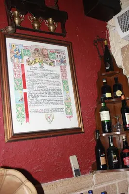 a picture hanging on a wall with bottles of wine at Hostal Restaurante La Diligencia in Cunit