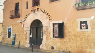 a building with a black door on the side of it at Hostal Restaurante La Diligencia in Cunit