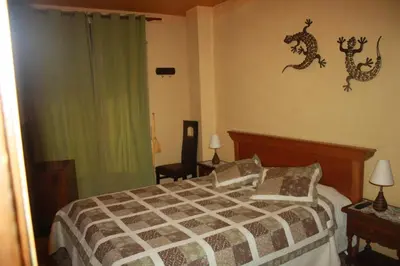 a bedroom with a bed with a lizard on the wall at Hostal Restaurante La Diligencia in Cunit