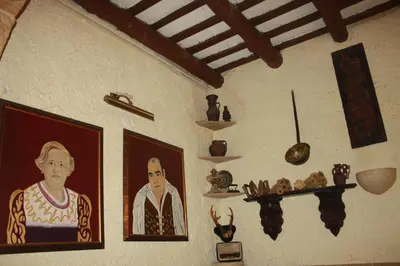 a wall with a painting of a woman andartifacts on it at Hostal Restaurante La Diligencia in Cunit