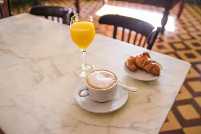 a table with a cup of coffee and a glass of orange juice at Hotel Robert in La Pobla de Claramunt