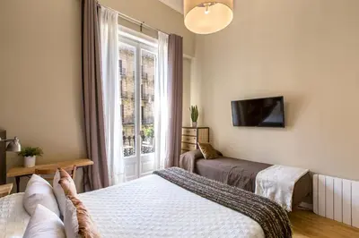 a bedroom with two beds and a window at El Born Guest House by Casa Consell in Barcelona