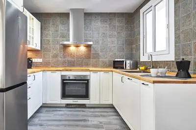 a kitchen with white cabinets and a stainless steel appliance at BBarcelona Fira Superior Flats in Barcelona
