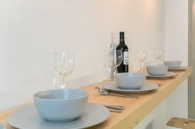 a table with bowls and glasses and a bottle of wine at Canela Homes BARCELONA MARINA in Barcelona