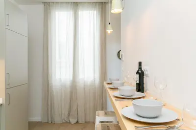 a kitchen with a table with bowls and wine glasses at Canela Homes BARCELONA MARINA in Barcelona