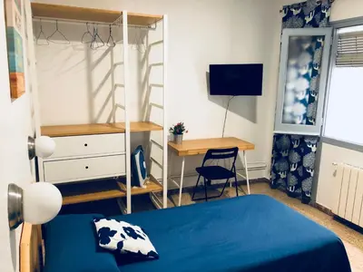 a bedroom with a bed and a desk and a computer at Hostal Carlos III in El Prat de Llobregat