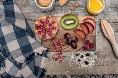 a wooden table with a cutting board with fruit and juice at CASA FILOMENA in Barcelona