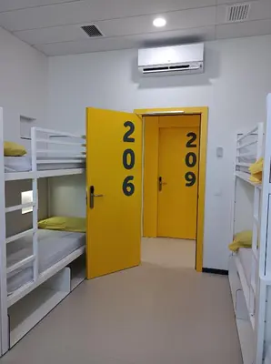 a room with two bunk beds and a yellow door at Alberg Barcelona Xanascat in Barcelona