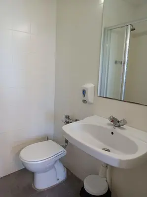 a white bathroom with a toilet and a sink at Alberg Barcelona Xanascat in Barcelona