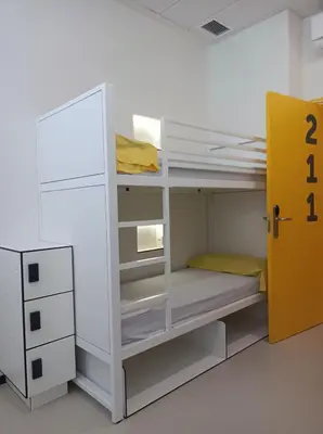 a room with a white bunk bed with a yellow door at Alberg Barcelona Xanascat in Barcelona
