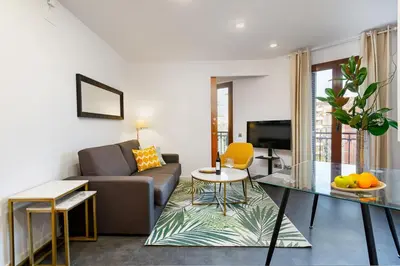 a living room with a couch and a table at Lodging Apartments City Center-Eixample in Barcelona