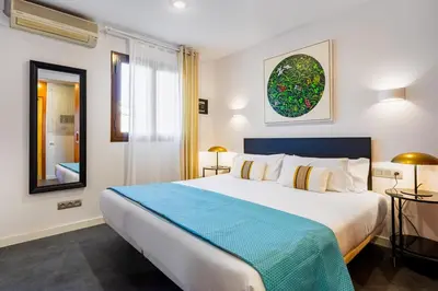 a bedroom with a large white bed and a window at Lodging Apartments City Center-Eixample in Barcelona