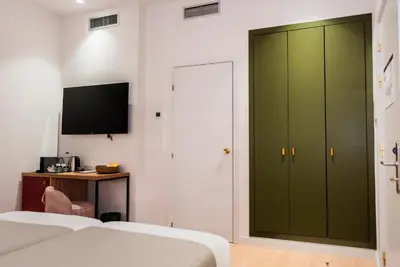 a bedroom with a green cabinet and a desk at Hotel California in Barcelona