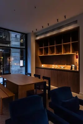 a dining room with a table and chairs and a bar at Hotel California in Barcelona